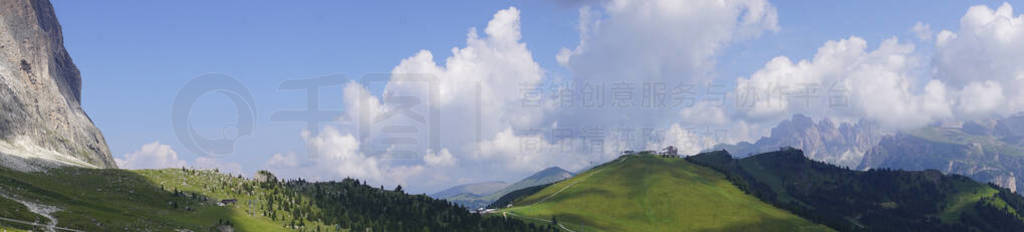 Panorama of sharp peaks rise above alpine summer meadows