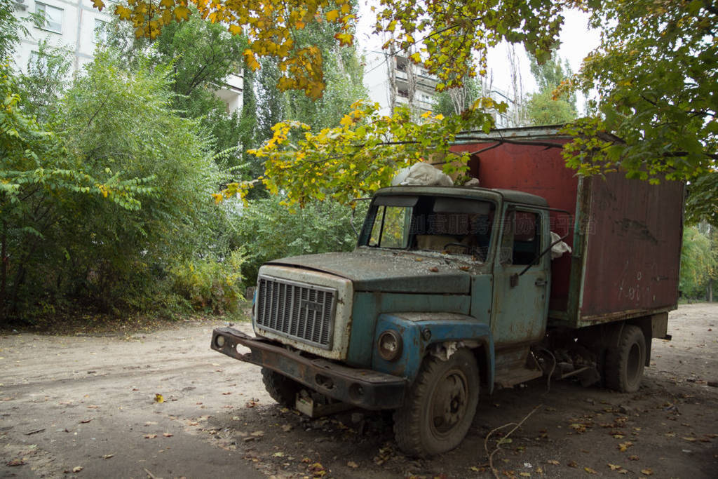 Old rusty truck with broken windows at abandoned overgrown part