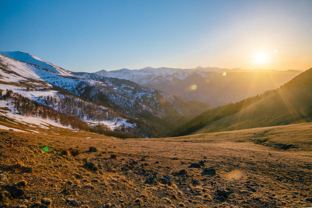 Beautiful evening sunset at Caucasian mountains with snow caps,