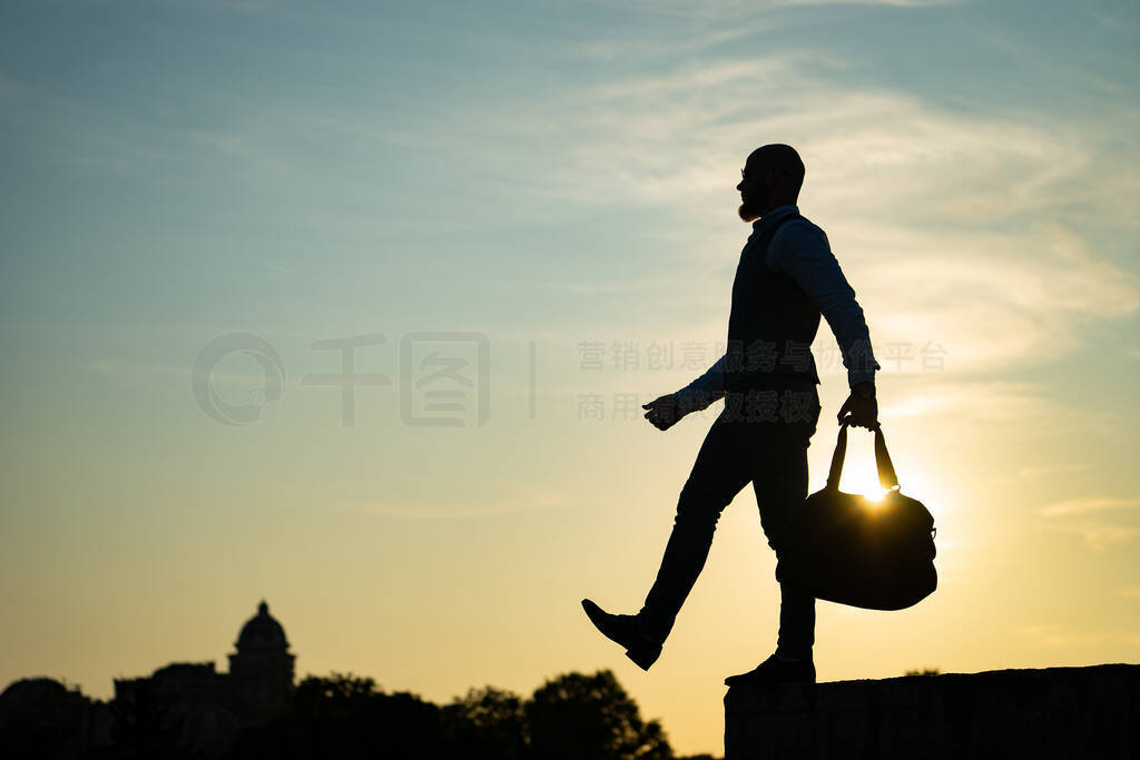 Man stepping from the edge during sunset on the sky background.