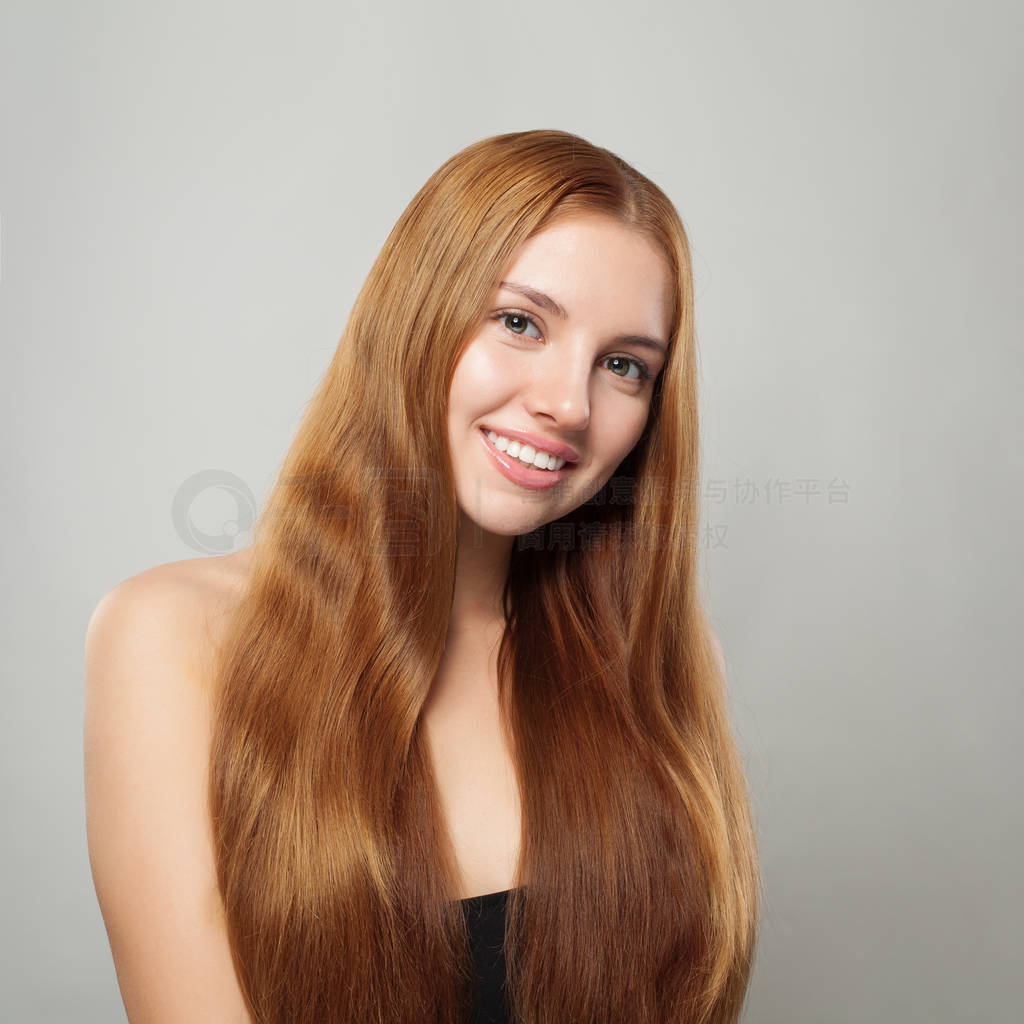 Pretty ginger haired woman with long healthy hair smiling