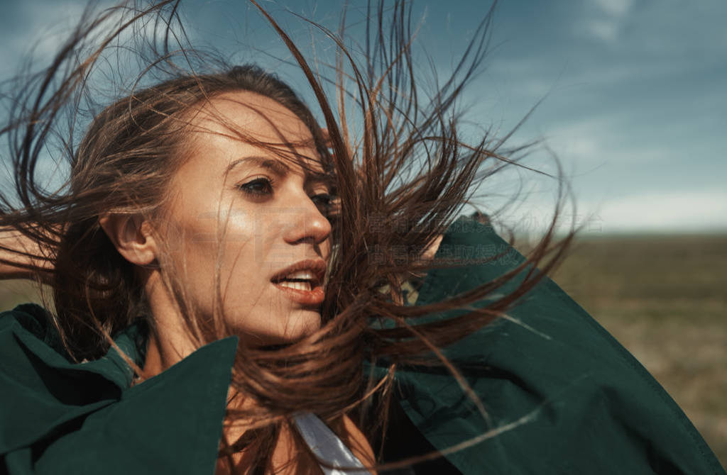 Woman outdoors with tousled wind blown hairs