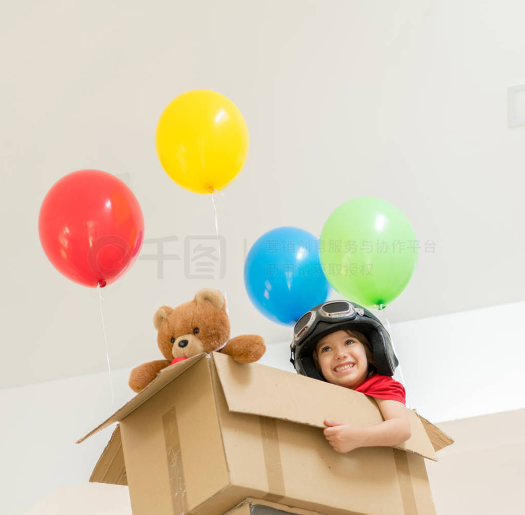 Happy boy sitting in his box imagining him self flying