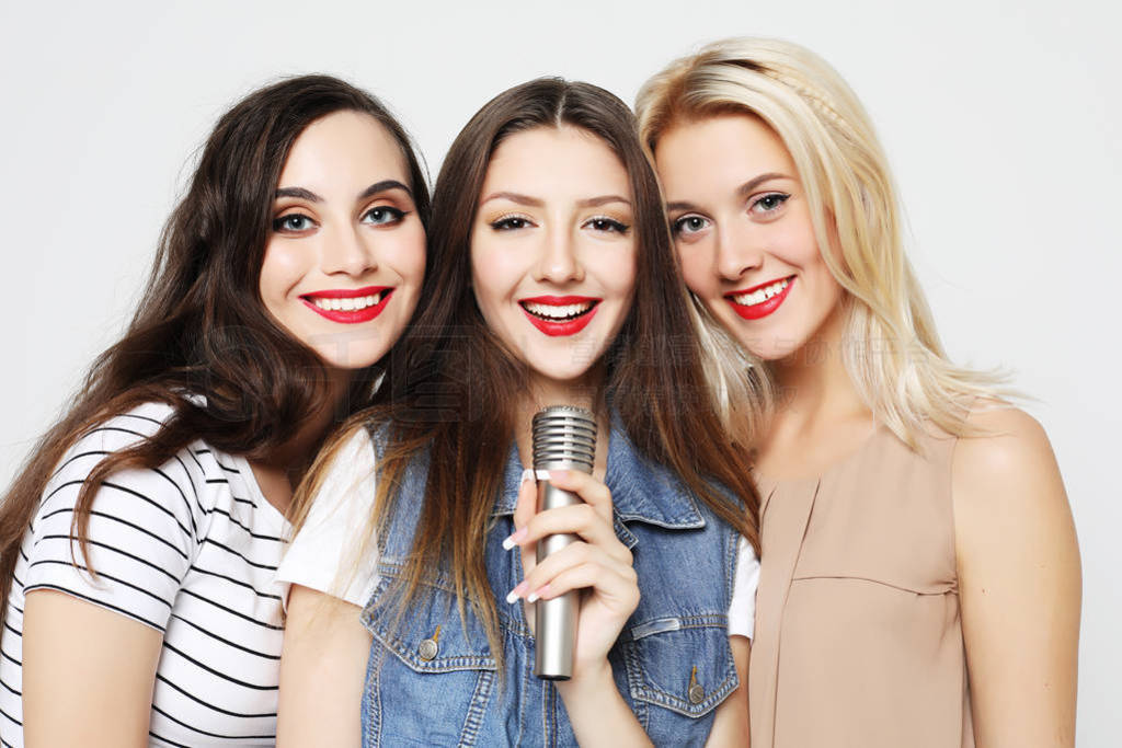 beauty girls with a microphone singing and having fun together