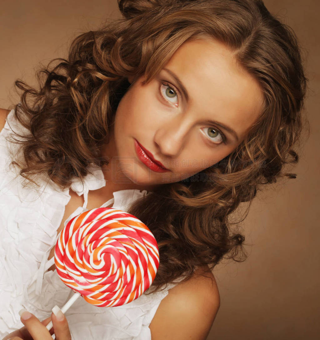 Beauty curly girl portrait holding colorful lollipop.