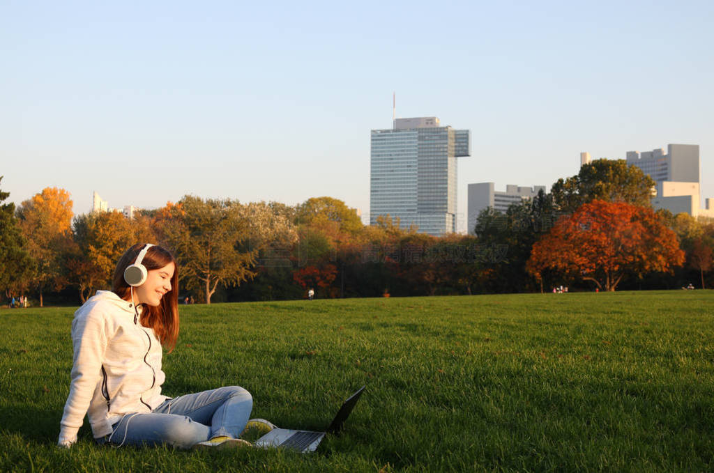 happy teenage girl with laptop in Donaupark Vienna sunny autumn