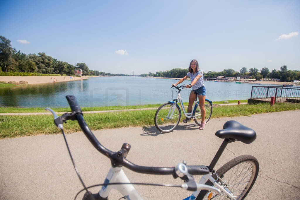 Young Woman Riding Bicycle In The Park