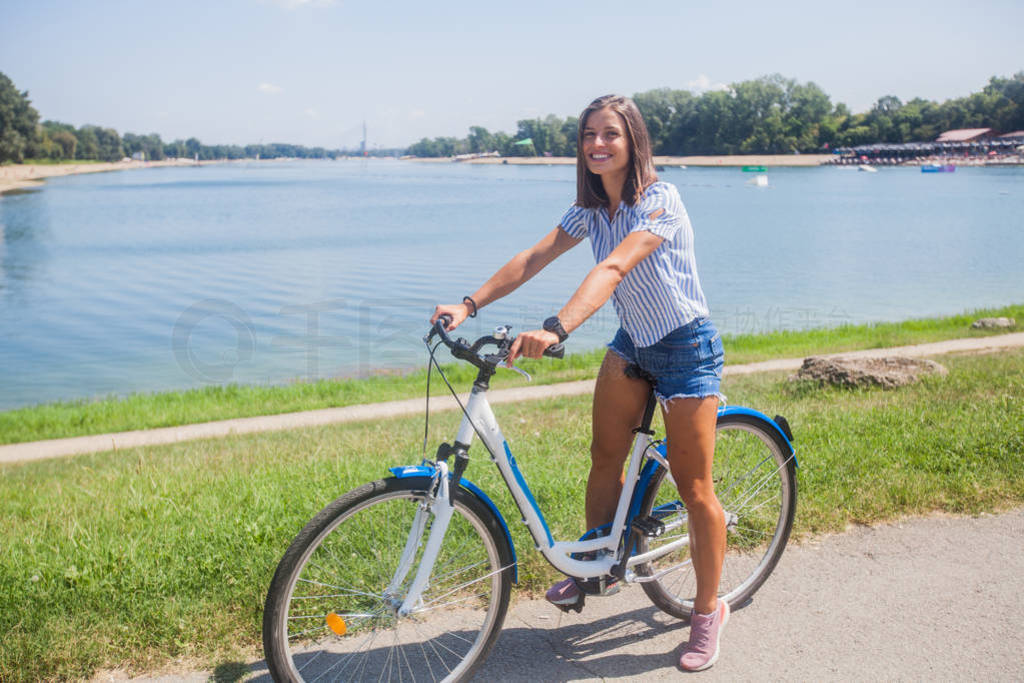 Young Woman Riding Bicycle In The Park