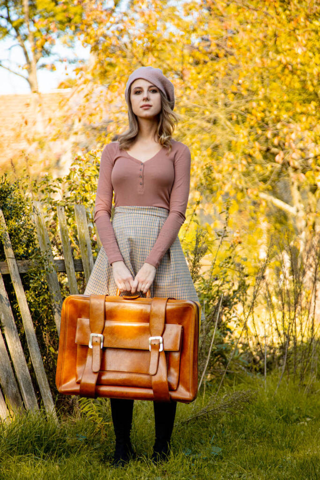 Style woman in vintage clothes with suitcase at outdoor