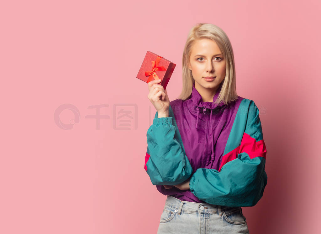 Beautiful blonde woman in 90s clothes with gift box