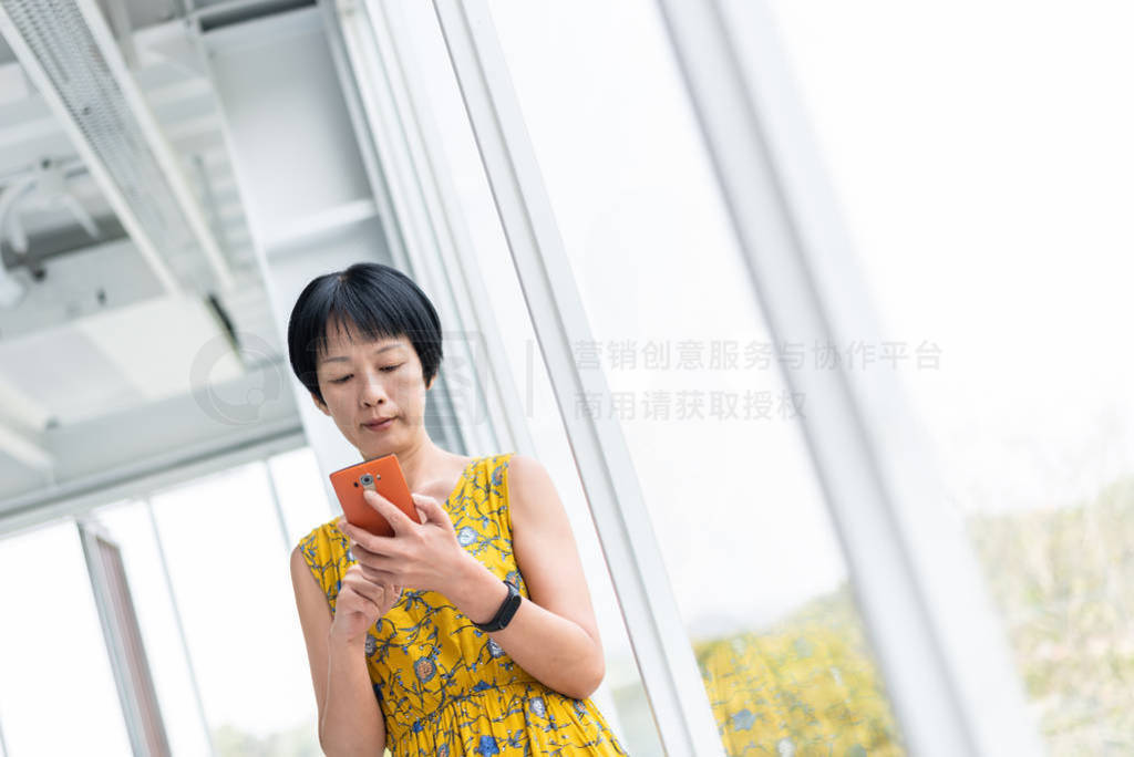 mature Asian woman using cellphone