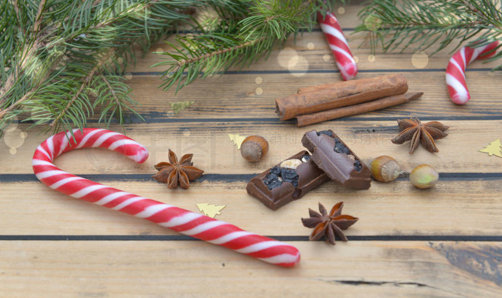 candy cane, chocolat and spices in christmas decoration on woode