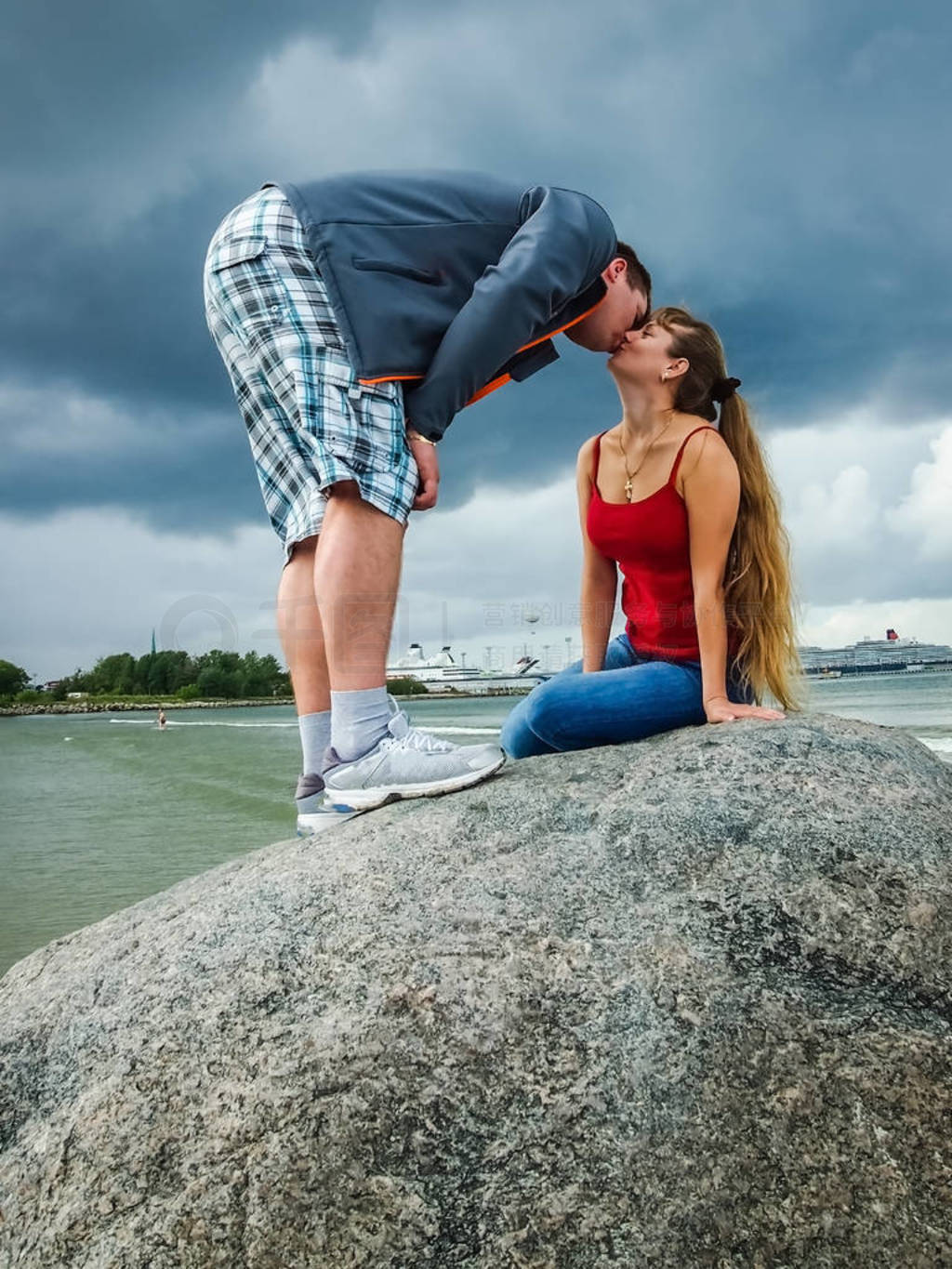 Girl in red and the guy sitting on the big rock