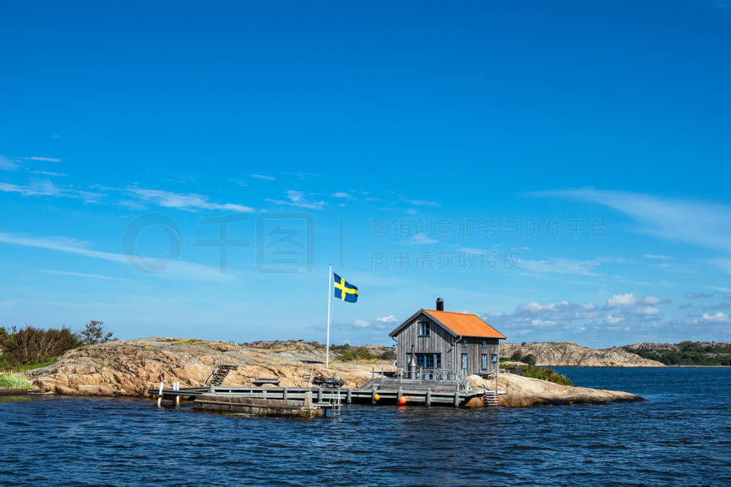 Cottage and flag on the island Valoen near the city Fjaellbacka