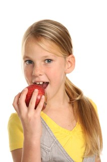 年轻的高中女生与多汁的红苹果
