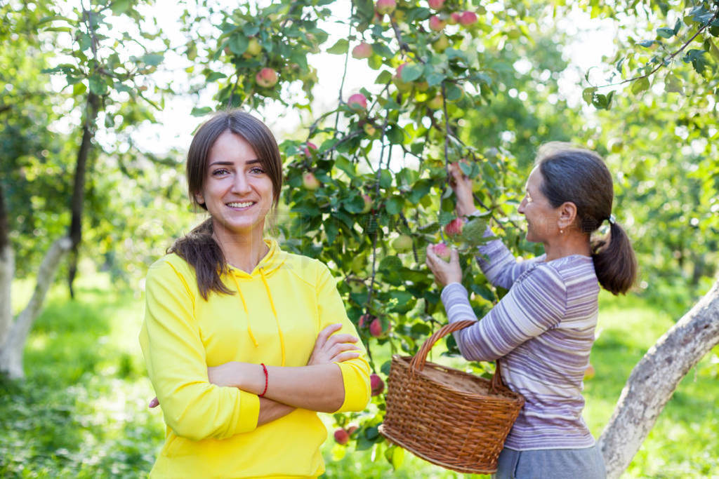 pretty girl next to mature mother in garden.