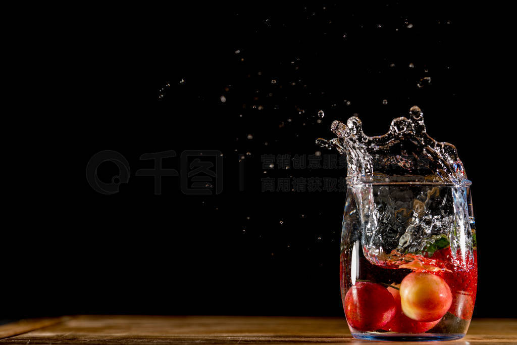 Fruits dropping into a glass of water. Flash strobes