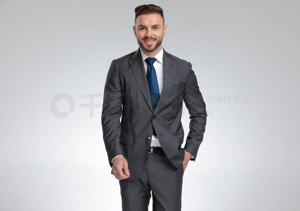 successful young businessman standing with hand in pocket