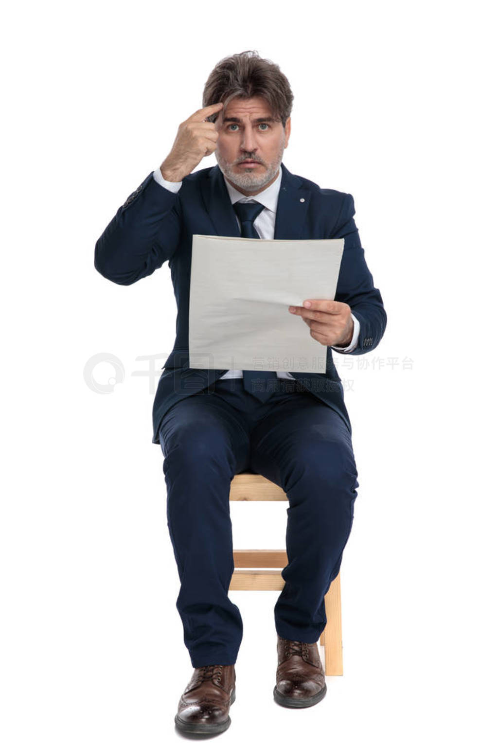 businessman sitting with newspaper on hand with crazy gesture