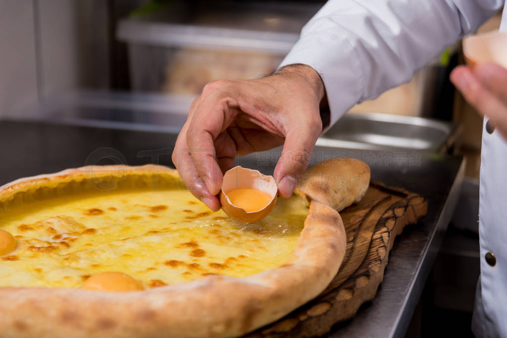 Chef cooking khachapuri with cheese and egg. Georgian national c