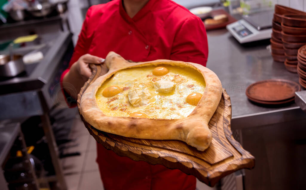 Chef cooking khachapuri with cheese and egg.