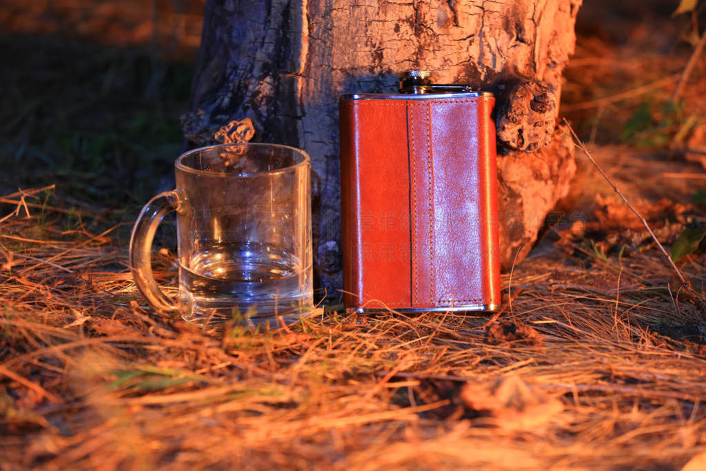 glass cup and steel flask in leather wrapper