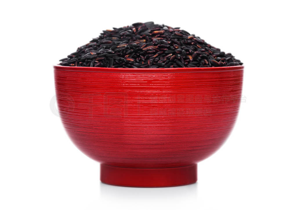 Red bowl of raw organic black venus rice on white background. He
