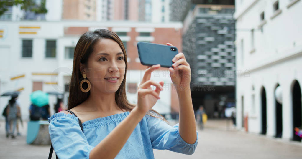 Woman tourist take photo on cellphone and visit old landmark in