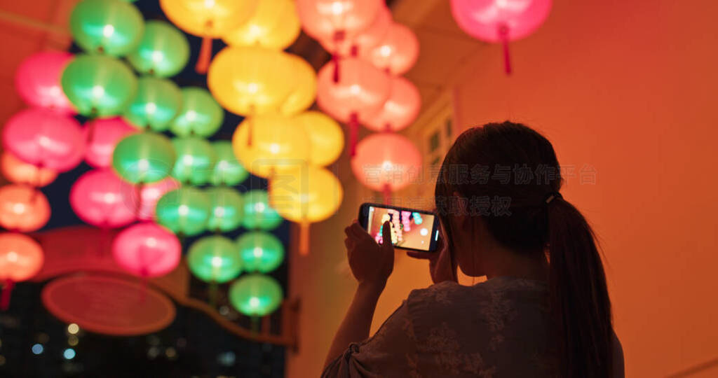 Woman take photo with cellphone on the chinese lantern
