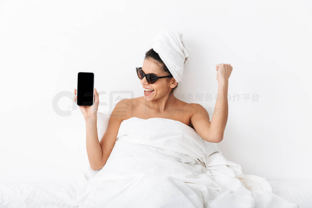 Image of cheery woman 30s wearing sunglasses wrapped in blanket