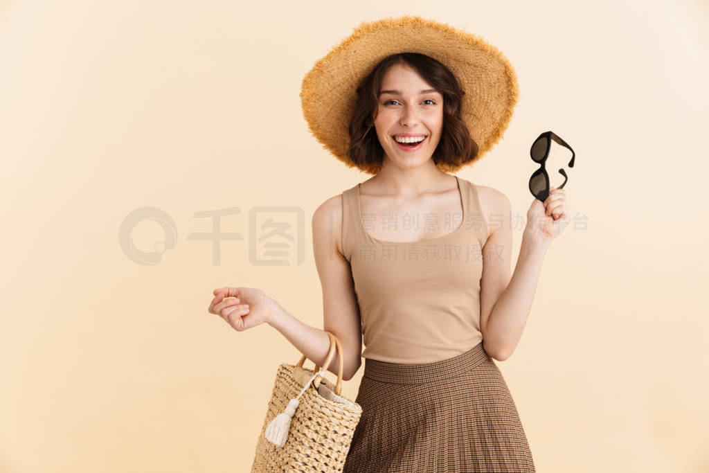 Portrait of cheerful brunette woman wearing straw hat posing at