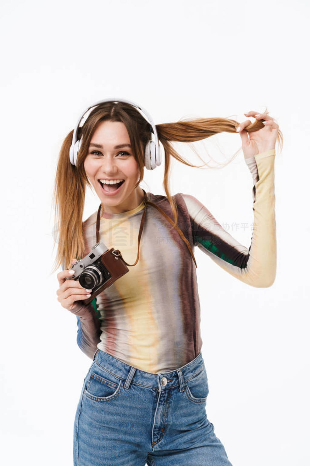 Portrait of cheerful young woman wearing headphones smiling and