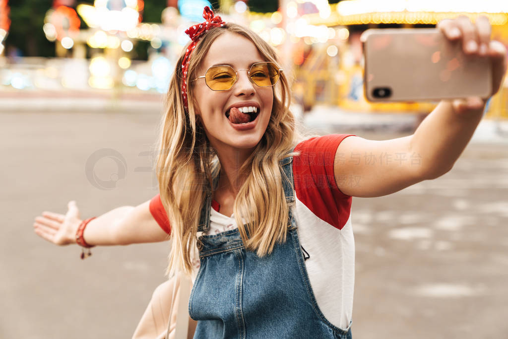 Image of cheerful blonde woman taking selfie photo on cellphone