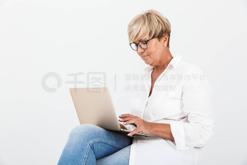 Image of attractive adult woman wearing eyeglasses sitting with