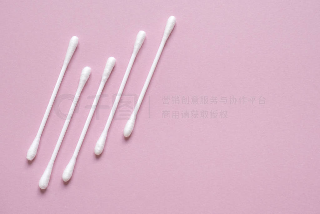 Flatlay white cotton buds for ears on pink with space for text.