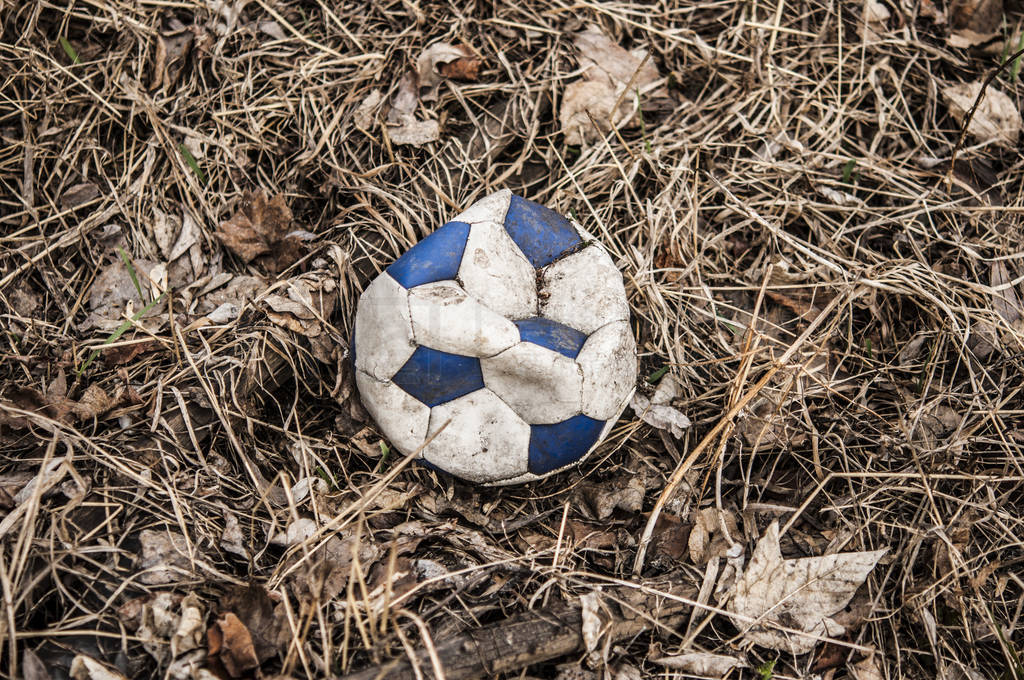 Old torn leather soccer ball blue and white