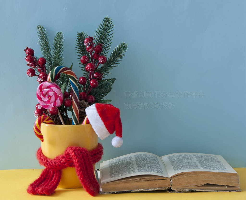 Christmas candy canes in yellow mug with berries holly branches