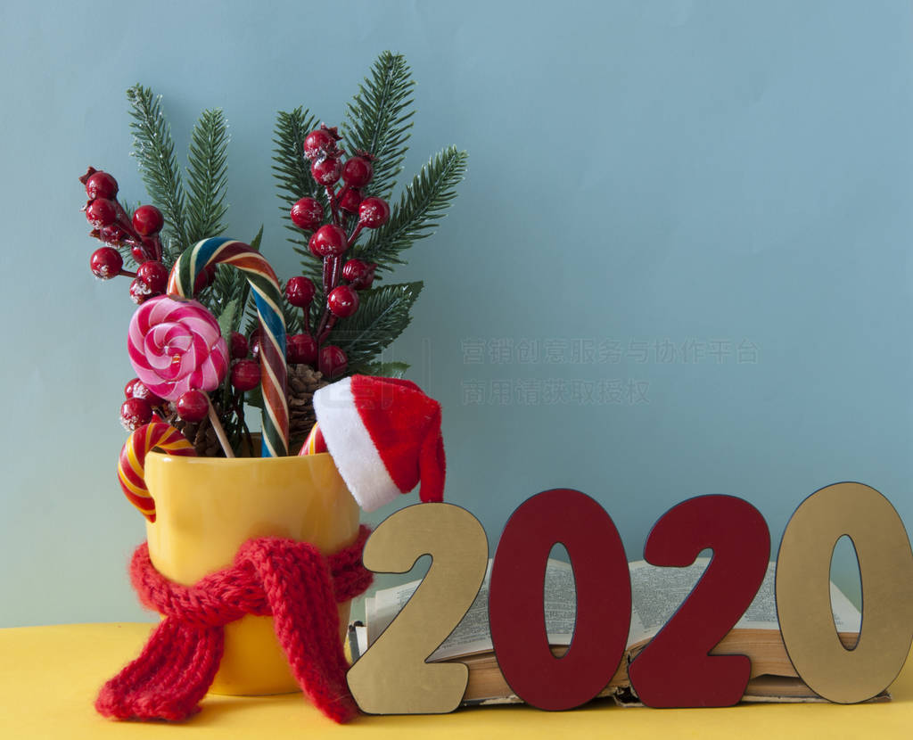 Christmas candy canes in yellow mug with berries holly branches