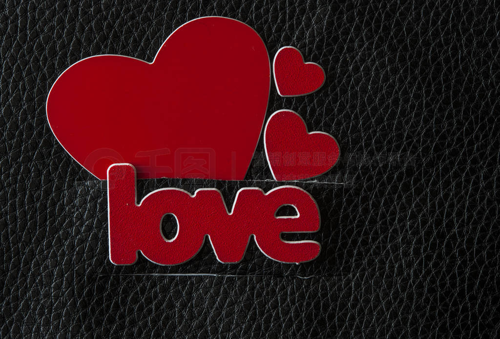 word Love with red hearts on black leather background. Greeting