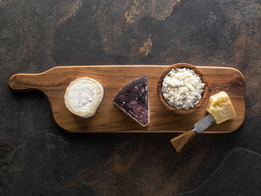 Cheese platter with different homemade organic cheeses on stone