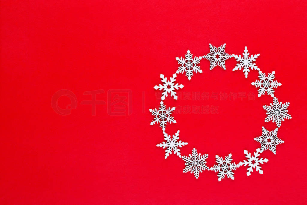 White snow flakes wreath decorations on red background.