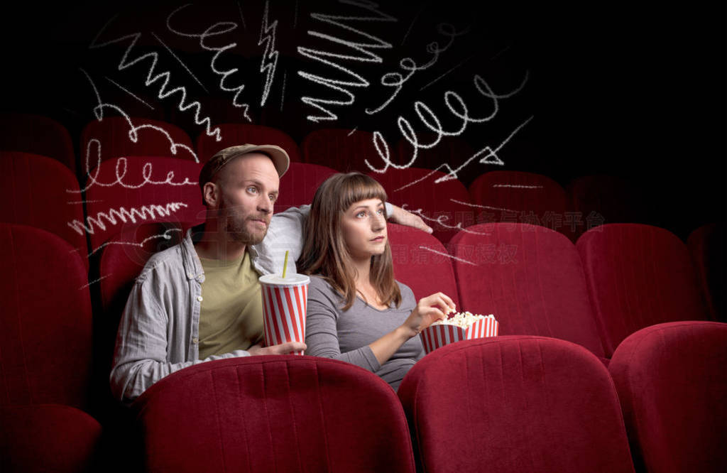 Cute couple in cinema watching movie