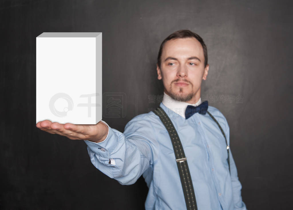 Handsome man showing empty box on his hand on blackboard