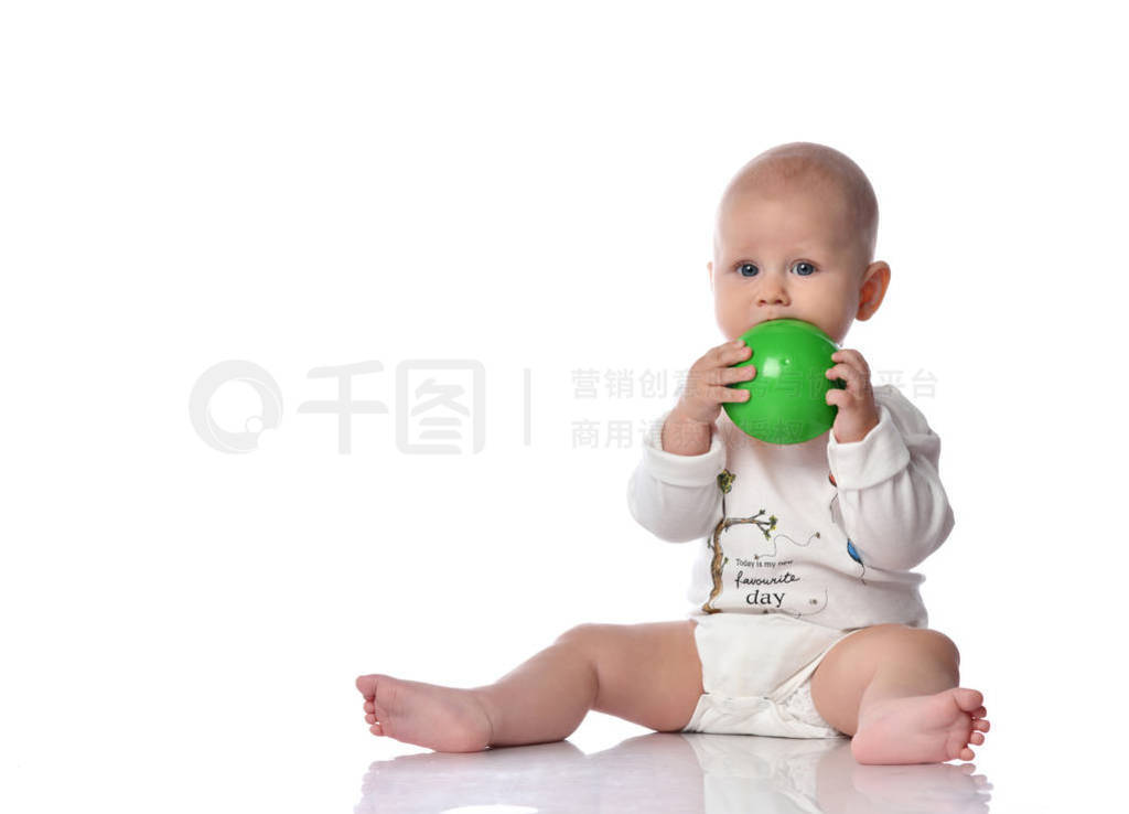 Infant child baby boy in diaper and white shirt is sitting wit