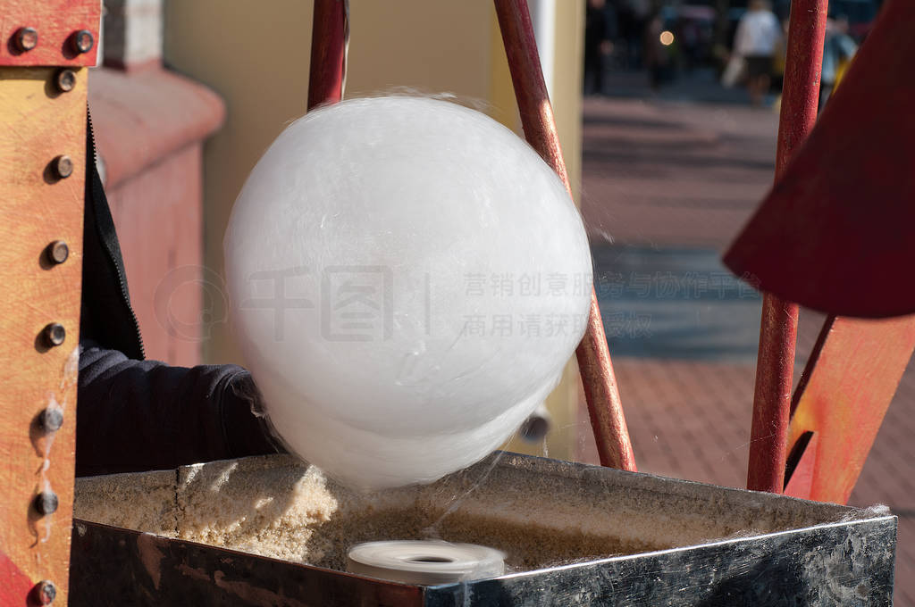 the process of making cotton candy, the seller winds a stick of