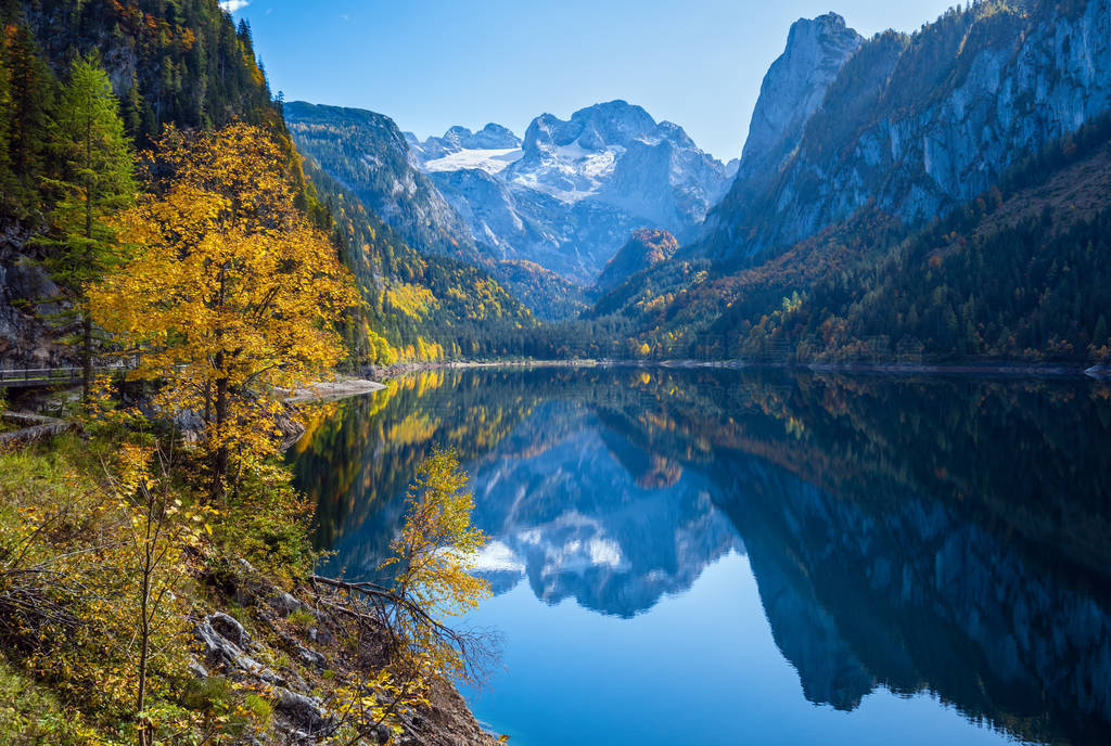 Peaceful autumn Alps mountain lake with clear transparent water