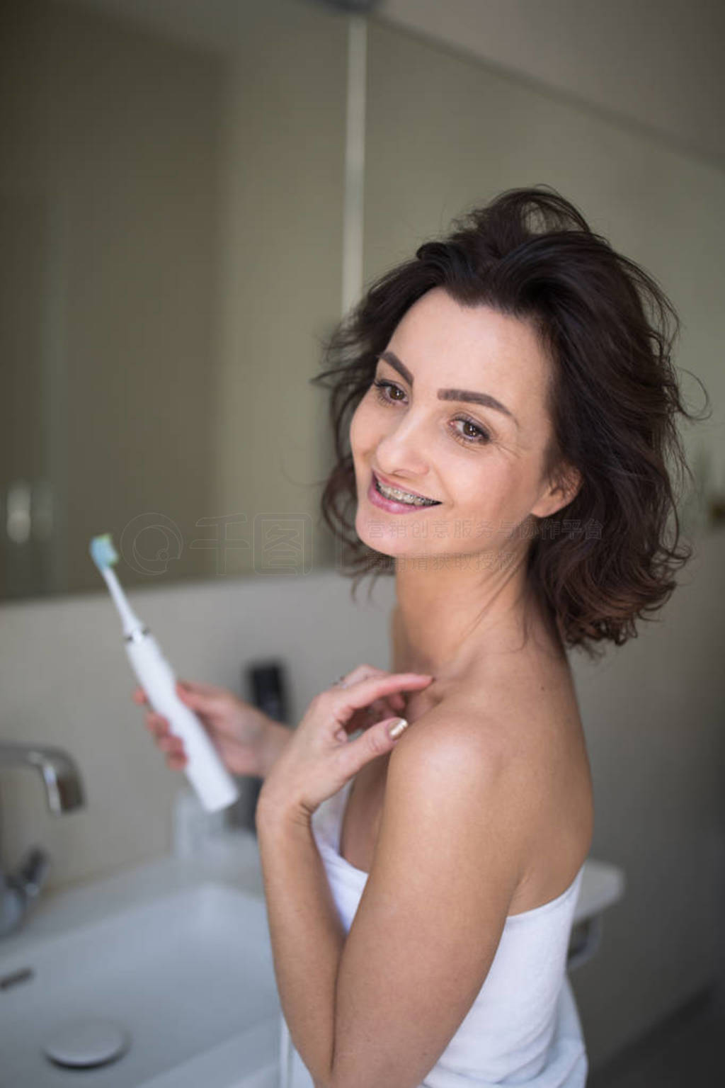 Pretty, middle aged woman brushing her teeth
