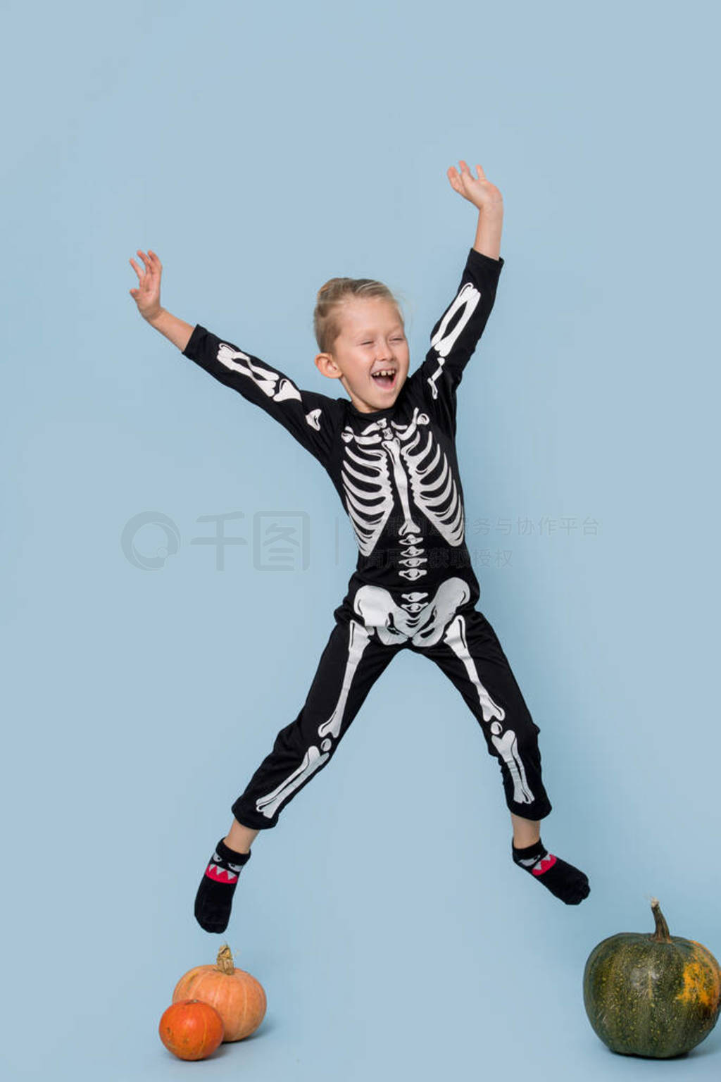 Boy in a skeleton costume having fun and jumping