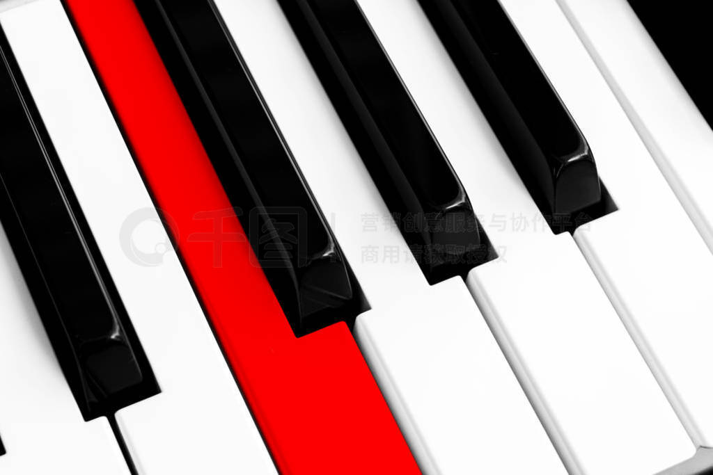 Top view of piano keys with one red button. Close-up of piano ke