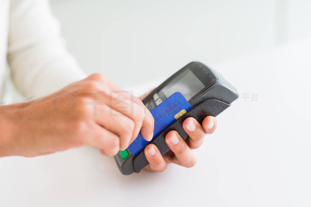 Close up of man hands holding point of sale terminal, dataphone